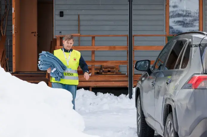 Frivillig Sanitetskvinne deler ut tepper under stengte veier pga sn&oslash;skred