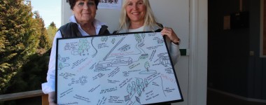 To sanitetskvinner viser kart over området på Hjørgunn gård