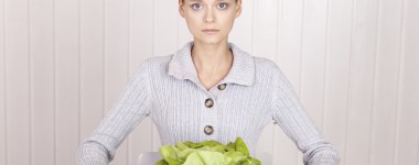 En jente som har spiseforstyrrelser sitter foran tallerken med grønne salatblader