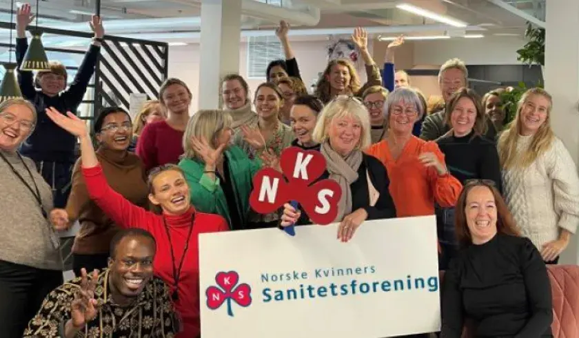 gruppebilde av kvinne som holder opp et banner