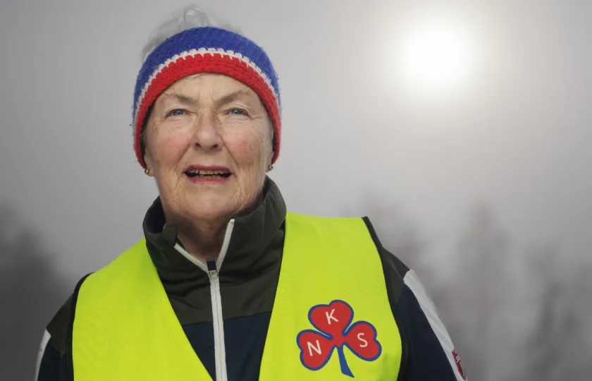 Sanitetskvinne med gull vest med kl&oslash;ver