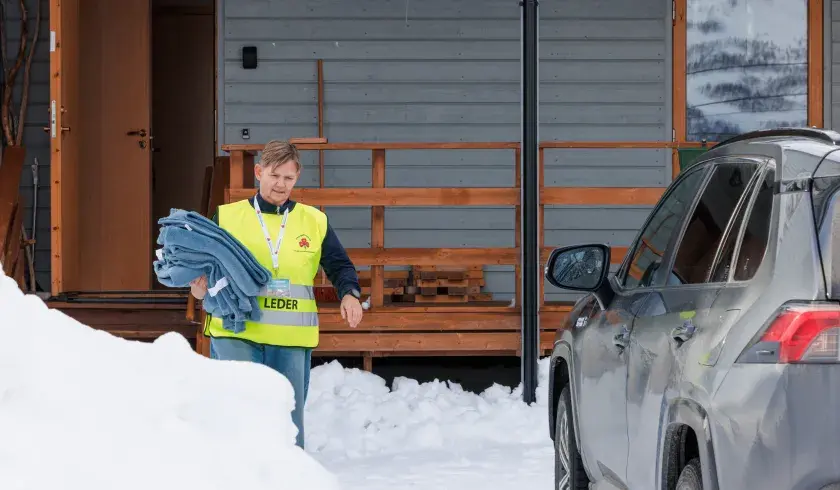 Frivillig Sanitetskvinne deler ut tepper under stengte veier pga sn&oslash;skred